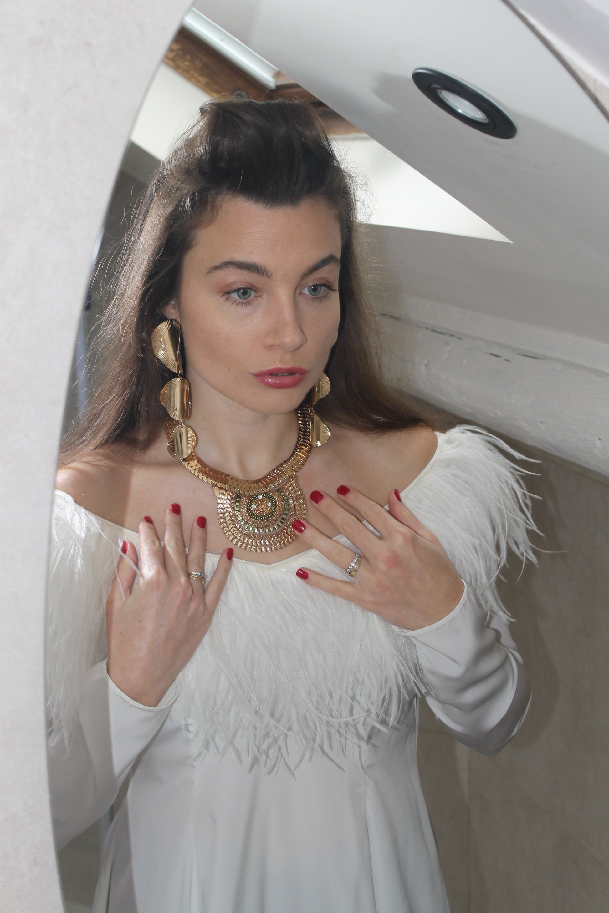 VOLIÀ Atelier - exclusively pre-loved. The founder wears the white sleek feather Barbara dress with the gold Chloé necklace.